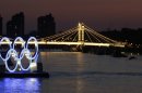 A boat passes a set of Olympic Rings floating in the River Thames off of Battersea park Tuesday, July 24, 2012, in London. The city will host the 2012 London Olympics with opening ceremonies scheduled for Friday, July 27. (AP Photo/Charlie Riedel)