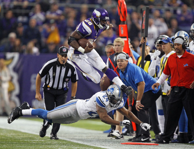 Minnesota Vikings running back Peterson leaps over Detroit Lions safety Coleman during the second half of their NFL football game in Minneapolis