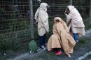 Migrants, who say they are minors, use blankets to protect themselves from the cold on a street after the dismantlement of the "Jungle" camp in Calais, France