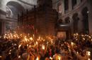 Christian pilgrims hold candles at the church of the Holy Sepulcher, traditionally believed to be the burial site of Jesus Christ, during the ceremony of the Holy Fire in Jerusalem's Old City, Saturday, April 19, 2014. The "holy fire" was passed among worshippers outside the Church and then taken to the Church of the Nativity in the West Bank town of Bethlehem, where tradition holds Jesus was born, and from there to other Christian communities in Israel and the West Bank. (AP Photo/Dan Balilty)