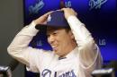 Newly signed Los Angeles Dodgers pitcher Kenta Maeda, from Japan, is introduced at a news conference in Los Angeles Thursday, Jan. 7, 2016. Maeda, 27, signed an eight-year contract with the baseball club that guarantees the right-hander $25 million, but he can earn more than $100 million during the length of the deal if he meets all performance incentives. (AP Photo/Nick Ut)