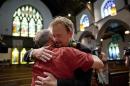United Methodist pastor Frank Schaefer, right, hugs the Rev. David Wesley Brown after a news conference Tuesday, June 24, 2014, at First United Methodist Church of Germantown in Philadelphia. Schaefer, who presided over his son's same-sex wedding ceremony and vowed to perform other gay marriages if asked, can return to the pulpit after a United Methodist Church appeals panel on Tuesday overturned a decision to defrock him. (AP Photo/Matt Rourke)