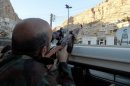 A Syrian pro-government soldier aims his rifle as he patrols the streets of Maalula on September 11, 2013