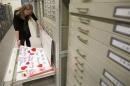 Archivist Marta Crilly looks through a file drawer of posters saved from the makeshift memorial that arose following the 2013 Boston Marathon bombings at the City Archives in Boston