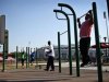 People work out in an outdoor "Adult Playground" exercise area at Macombs Dam Park in the Bronx section of New York City