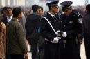 Policemen use a scanner to check the identity card of a man walking towards Beijing's Tiananmen Square