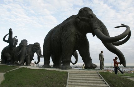 FILE - In this June 28, 2008 file photo a sculpture of mammoths is seen in the Siberian town of Khanty-Mansiisk, 2000 kilometers (1250 miles) east of Moscow, Russia. A Russian university said Tuesday that an international team of scientists have discovered well-preserved frozen woolly mammoth fragments deep in Siberia that may contain living cells, edging a step closer to the possibility of cloning the prehistoric animal. (AP Photo/Dmitry Lovetsky,File)