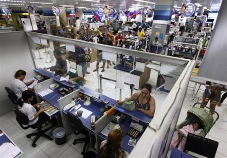 People wait in line at a branch of Bradesco bank, inside a Casas Bahia store in Sao Paulo February 18, 2013. REUTERS/ Nacho Doce