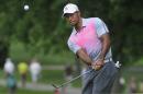 Tiger Woods watches his chip to the fourth hole, during the first round of the Bridgestone Invitational golf tournament, Thursday, July 31, 2014, in Akron, Ohio. (AP Photo/Phil Long)