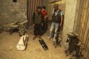 Members of the Free Syrian Army check an improvised mortar shell in Deir al-Zor