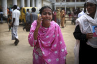 A young lady wails over the phone as she tells her family that she had identified one of the many bodies at a morgue to be her relative, Saturday, May 4, 2013 in Savar, near Dhaka, Bangladesh. In the aftermath of a building collapse that killed more than 530 people, Bangladesh's garment manufacturers may face a choice of reform or perish. (AP Photo/Wong Maye-E)