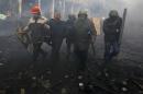 Anti-government protesters detain a policeman during clashes in the Independence Square in Kiev