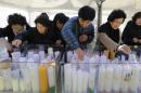 Parents light candles for their children' success in the Scholastic Aptitude Test at the Jogye Temple in Seoul, South Korea, Thursday, Nov. 13, 2104. About 640,000 high school students and graduates in South Korea are scheduled to take the examination Thursday that will virtually determine their admission to college. (AP Photo/Ahn Young-joon)