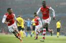 Arsenal's Yaya Sanogo, right, celebrates scoring with teammate Alex Oxlade-Chamberlain during the Champions League group D soccer match between Arsenal and Borussia Dortmund at the Emirates stadium in London, Wednesday, Nov. 26, 2014. (AP Photo/Alastair Grant)