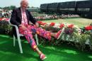 FILE - In this June 30, 1993, file photo, NBC tennis commentator Bud Collins displays a pair of brightly-colored trousers as he sits overlooking the outside courts at Wimbledon, England . Collins, the tennis historian and American voice of the sport in print and on TV for decades, died Friday, March 4, 2016 at home in Brookline, Mass., his wife, Anita Ruthling Klaussen said. He was 86. (AP Photo/Gill Allen, File)