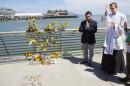 Father Cameron Faller, right, and Julio Escobar, of Restorative Justice Ministry, conduct a vigil for Kathryn Steinle, Monday, July 6, 2015, on Pier 14 in San Francisco. Steinle was gunned down while out for an evening stroll at Pier 14 with her father and a family friend on Wednesday, July 1. (AP Photo/Beck Diefenbach)