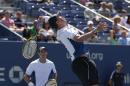 Bob Bryan, right, leaps for a shot as Mike Bryan looks on during a semifinal doubles match against Scott Lipsky and Rajeev Ram during the 2014 U.S. Open tennis tournament, Thursday, Sept. 4, 2014, in New York. (AP Photo/Julio Cortez)