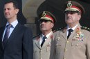 FILE - In this Thursday Oct. 6, 2011 photo released by the Syrian official news agency SANA, Syrian President Bashar Assad, left, stands next to Syrian Defense Minister Gen. Dawoud Rajha, right, during a ceremony to mark the 38th anniversary of the October 1973 Arab-Israeli war, in Damascus, Syria. Syria's state-run TV says the country's defense minister has been killed in a suicide blast in the capital. Wednesday's attack struck the National Security building in Damascus during a meeting of Cabinet ministers and senior security officials. (AP Photo/SANA, File)