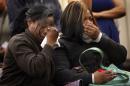 Tiffany Roberson, left, and Sharice Burns, sisters of Jamar Clark, watch a video taken at the scene where Clark was killed as as Hennepin County Attorney Mike Freeman announces Wednesday, March 30, 2016, that no charges will be filed against two Minneapolis police officers in the fatal shooting of a Clark, last November, in Minneapolis. Community activists in Minneapolis say they don’t accept the prosecutor’s decision. (Jim Gehrz/Star Tribune via AP)