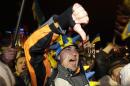 Protesters react during an opposition meeting at Independence square in Kiev