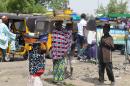 Child food vendors carry trays stacked with food plates at Post Office Area in the northeast Nigerian city of Maiduguri on May 24, 2014