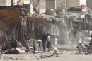 Residents are seen near damaged buildings at Marat al-Numan, near the northern province of Idlib