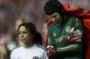 Chelsea goalkeeper Petr Cech holds his arm as he is covered by a blanket as he leaves the pitch following an injury during the Champions League semifinal first leg soccer match between Atletico Madrid and Chelsea at the Vicente Calderon stadium in Madrid, Spain, Tuesday, April 22, 2014 .(AP Photo/Paul White)