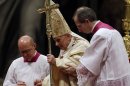 Pope Benedict XVI is helped on to the altar by Bishop Guido Marini, right, during the Christmas Eve Mass in St. Peter's Basilica at the Vatican, Monday, Dec. 24, 2012. (AP Photo/Gregorio Borgia)