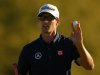 Adam Scott of Australia holds up his ball after sinking a par putt on the 18th green during third round play in the 2013 Masters golf tournament in Augusta