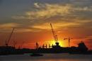 A shipyard is silhouetted against the rising sun in Dalian