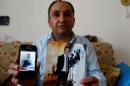 Kipcak shows photographs of his son Murat during an interview with Reuters in Istanbul