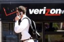 FILE - In this Monday, July 28, 2008, file photo, Eric Roden speaks on his cell phone as he walks past a Verizon store in Portland, Ore. Verizon says, Monday, Sept. 2, 2013, it has agreed to buy Vodafone's stake in Verizon Wireless for $130 billion. (AP Photo/Don Ryan, File)