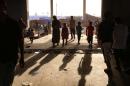 Iraqis who fled violence in the northern city of Tal Afar, walk at the Bahrka camp that hosts displaced people, in the autonomous Kurdistan region, on July 12, 2014