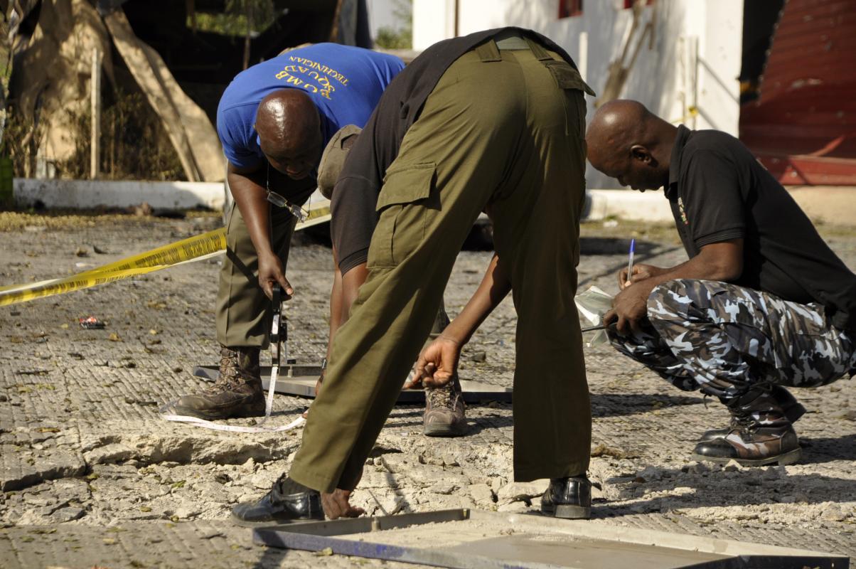 Police officers inspect the site of a blast at a petrol station in Kano, Nigeria. Saturday, Nov. 15, 2014. A bomb exploded Friday night in northern Kano city, the second largest population center in Nigeria, killing six people including three police officers, according to the police. (AP Photo/Muhammed Giginyu)