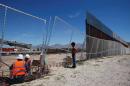 A boy looks at U.S. workers building a section of the U.S.-Mexico border wall at Sunland Park, U.S. opposite the Mexican border city of Ciudad Juarez