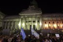 People wave Argentine flags as they attend a demonstration to protest against an agreement between Argentina and Iran outside the Argentine Congress in Buenos Aires