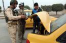 Iraqi soldiers check a motorist at a checkpoint east of Baghdad on January 10, 2014