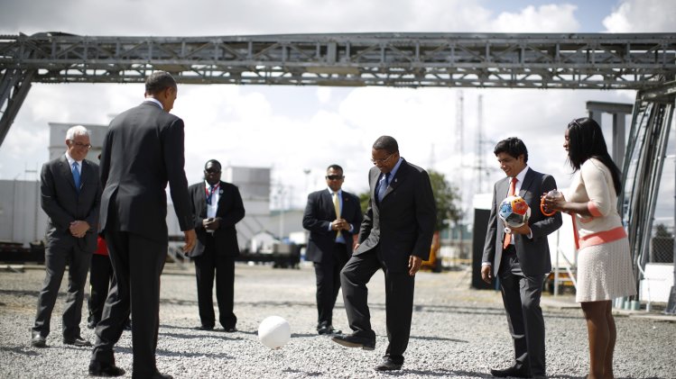 U.S. President Obama kicks a soccer ball to Tanzania's President Kikwete during a demonstration at the Ubungo Power Plant in Dar es Salaam