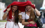Two women react, as they arrive for the opening of the famous Bavarian "Oktoberfest" beer festival as rain falls, in Munich, southern Germany, Saturday, Sept. 22, 2012. The world's largest beer festival, to be held from Sept. 22 to Oct. 7, 2012 will see some million visitors. (AP Photo/Matthias Schrader)