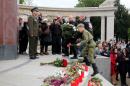 Members of the Russian motorcycle club Night Wolves lay a wreath in front of the Hero Monument of the Red Army in Vienna, Austria, Saturday, May 2, 2015. The Night Wolves want to ride through Belarus, Poland, Slovakia, the Czech Republic and Austria to Berlin to commemorate the victory of Soviet troops over Nazi Germany 70 years ago. (AP Photo/Ronald Zak)