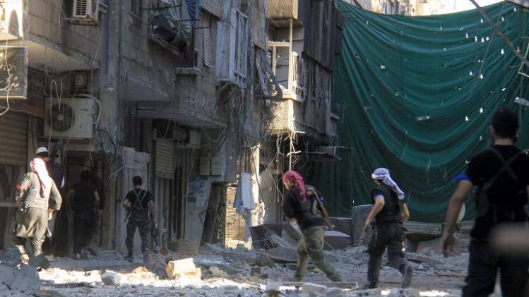 Rebel fighters take position on a front line in the Yarmuk refugee camp in Damascus on September 11, 2013