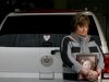 In this Saturday, Dec. 22, 2012 photo, Judy Neiman holds a photo of her daugher, Sydnee, in front of her 2006 Cadillac Escalade at her home in West Richland, Wash. Sydnee died in late 2011 after Neiman accidentally backed over her with the SUV. Although there is a law in place that calls for new manufacturing requirements to improve the visibility behind passenger vehicles, the standards have yet to be mandated because of delays by the U.S. Department of Transportation. (AP Photo/Kai-Huei Yau)