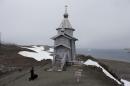 In this Feb. 1, 2015 photo, Russian Orthodox priest Sophrony Kirilov, 38, walks to the Holy Trinity Church, precariously perched on a rocky hill on King George Island, Antarctica. Russian priests here rotate in for yearlong stints, primarily to celebrate Mass for the workers on the Russian Bellinghausen base, which number between 15 and 30 people at a time. (AP Photo/Natacha Pisarenko)