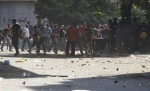 Police men and residents throw stones in front of Azbkya …