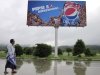 FILE - In this Aug. 11, 2012 file photo, a man walks past a Pepsi advertisement in Naypyitaw, Myanmar. PepsiCo Inc. will start selling its drinks in Myanmar, following the U.S. government's decision to suspend investment sanctions on the country for its democratic reforms. Myanmar's new foreign investment law envisions broad powers for the country's already over-taxed investment commission, restricts foreign investment in 11 poorly defined areas and requires local hiring, according to a copy of the widely misunderstood law obtained by The Associated Press. (AP Photo/Khin Maung Win, File)