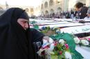 Mourners gather next to coffins of fifty unidentified bodies, found in mass graves in Basra, Nasiriyah and Babel, during their funeral outside Shiite Imam Ali's Shrine in the holy city of Najaf, central Iraq, on February 24, 2014