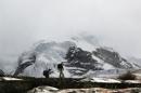 People walk near the Hualcan glacier in the Huascaran natural reserve in Ancash