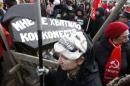 An activist wears a skull mask as he stands near a cart with a fake coffin reading "There was no hospital bed for me" during a protest in support of Russian doctors and patients against reforms to the healthcare system in Moscow