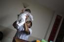 A nurse carries a child in the San Jose Hospice in Sacatepequez