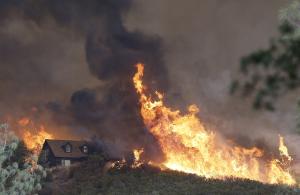 Fires approach a home near Lower Lake, Calif., Friday, &hellip;